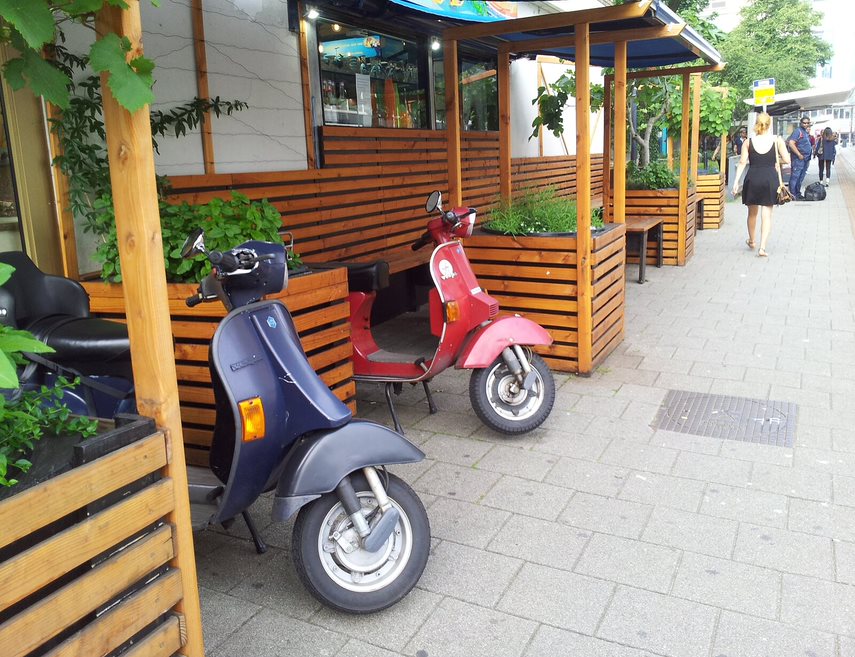 Afbeelding met buiten, grond, geparkeerd, scooter Automatisch gegenereerde beschrijving
